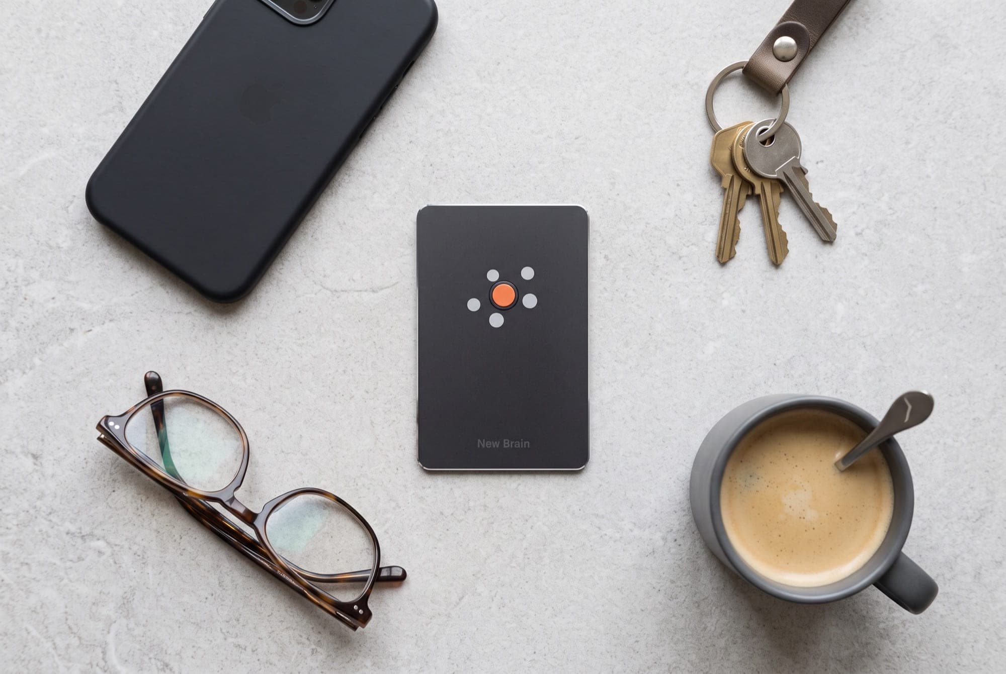 New Brain Card laid out on a desk beside a phone, a notebook and a pen