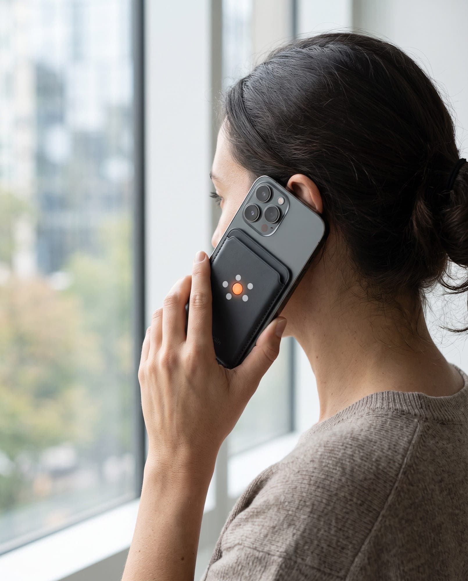 Someone on a phone call with New Brain Card in its magnetic wallet on the back of the phone