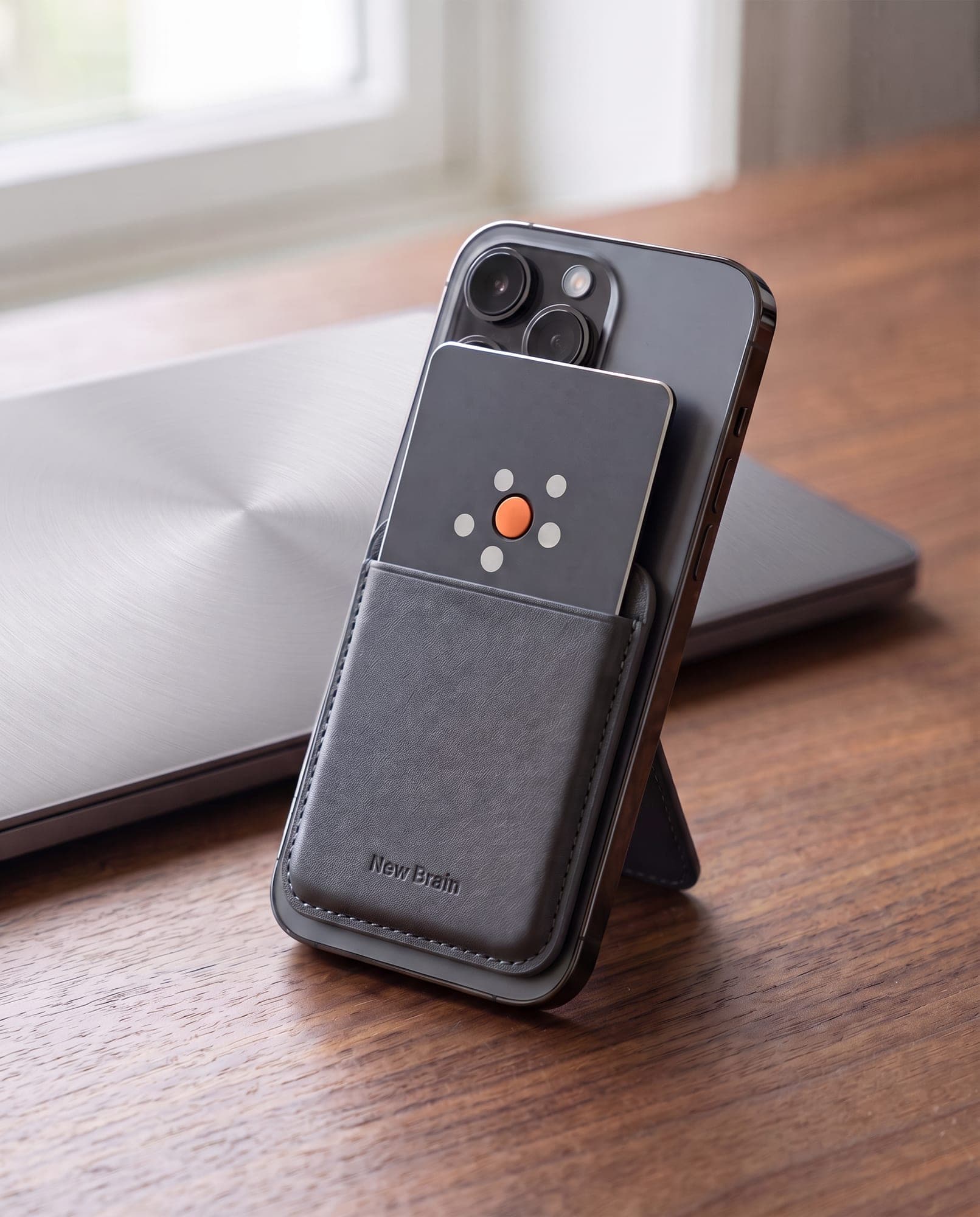 A phone standing on its folded-out wallet, New Brain Card in the pocket on its back